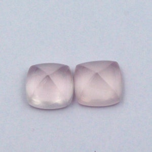 Könnte beinhalten: Zwei quadratische Edelsteine in blassrosa mit facettiertem Design.