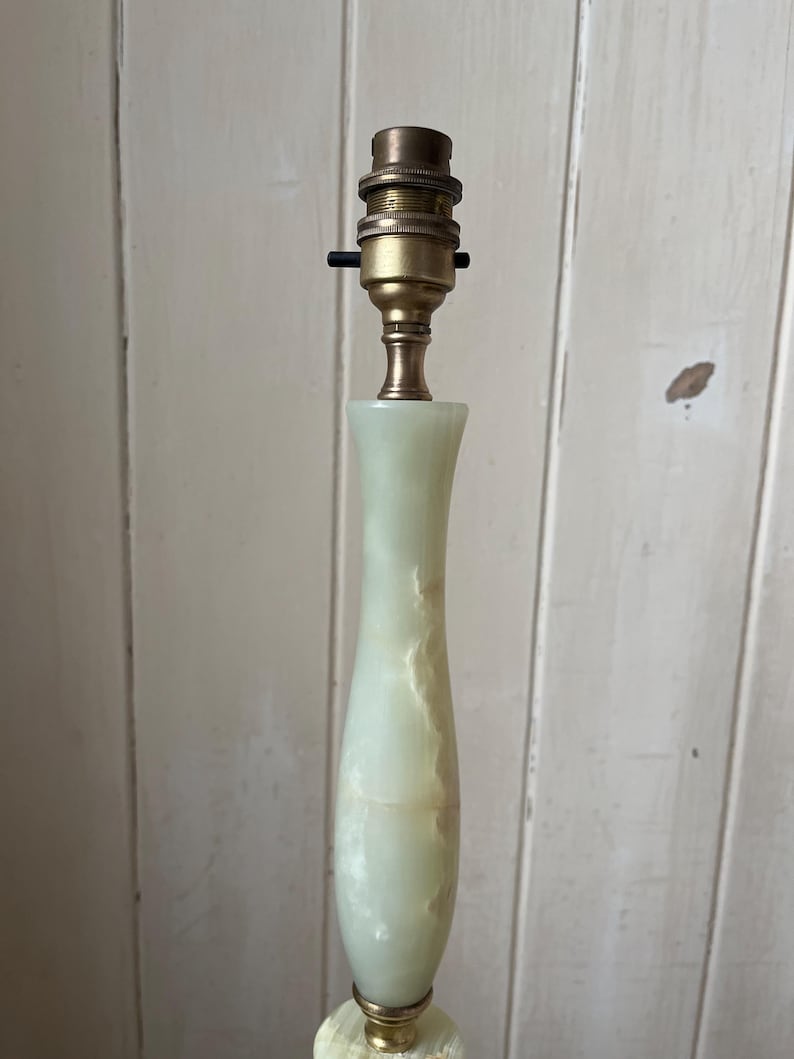 Peut inclure: Une lampe haute avec un pied en onyx vert p&acirc;le et un support de lampe en laiton. L'onyx pr&eacute;sente de subtiles veines, ajoutant &agrave; sa beaut&eacute; naturelle. La lampe est con&ccedil;ue pour une ampoule standard.