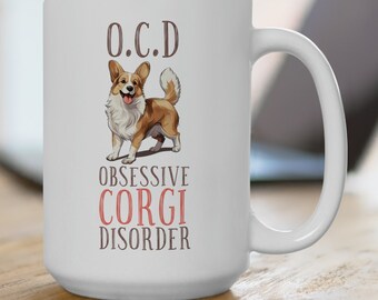 May include: White ceramic mug featuring a corgi illustration with the text "O.C.D. Obsessive Corgi Disorder." The corgi is depicted in shades of brown, white, and tan. The mug has a large handle and is suitable for hot or cold beverages.