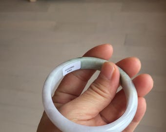 May include: A light lavender jade bangle bracelet with a white tag that reads "F2441000 4281".