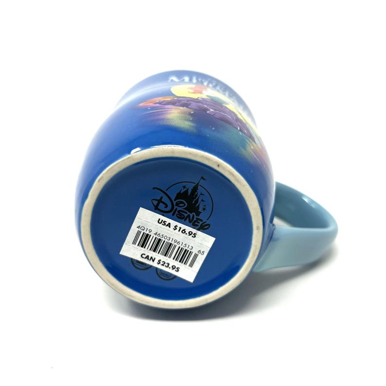 Pu&ograve; includere: Una tazza di ceramica blu con un manico azzurro. La tazza presenta un design colorato e il logo Disney sul fondo. Un'etichetta del prezzo &egrave; visibile sul fondo della tazza.