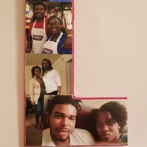 Pu&ograve; includere: Una lettera "L" in legno decorata con diverse fotografie. Le foto mostrano persone in vari contesti, tra cui un matrimonio, la cucina e ritratti casuali. La lettera ha un bordo rosa.