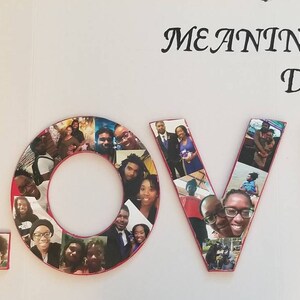 Pu&ograve; includere: Un pezzo decorativo che dice "LOVE" con foto. Ogni lettera &egrave; riempita con varie immagini e le lettere sono delineate in rosso. Le parole "MEANINGFUL DECOR" sono scritte sopra le lettere in un carattere decorativo.