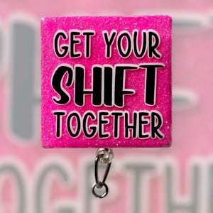 May include: Pink glitter badge holder with a black and white text overlay that reads "Get Your Shift Together".