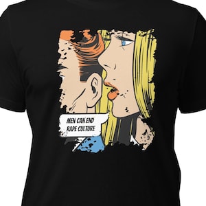 May include: Black t-shirt featuring a comic book-style graphic. The graphic depicts two figures in profile, with a speech bubble that reads "MEN CAN END RAPE CULTURE". The artwork uses bold lines and primary colors.