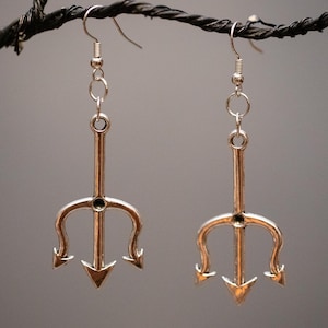 May include: Silver tone trident earrings with a simple chain and hook closure.