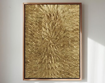 May include: A rectangular gold-colored textured artwork in a wooden frame. The artwork features a central, textured design resembling overlapping petals or leaves. The frame is a warm, medium brown color.