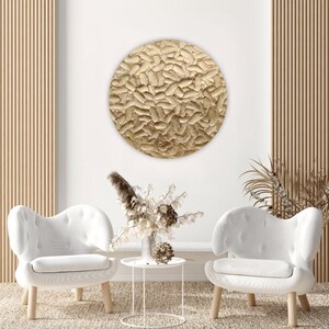Circular gold painting with textured and sculptural details, perfect for adding elegance to living room wall decor.