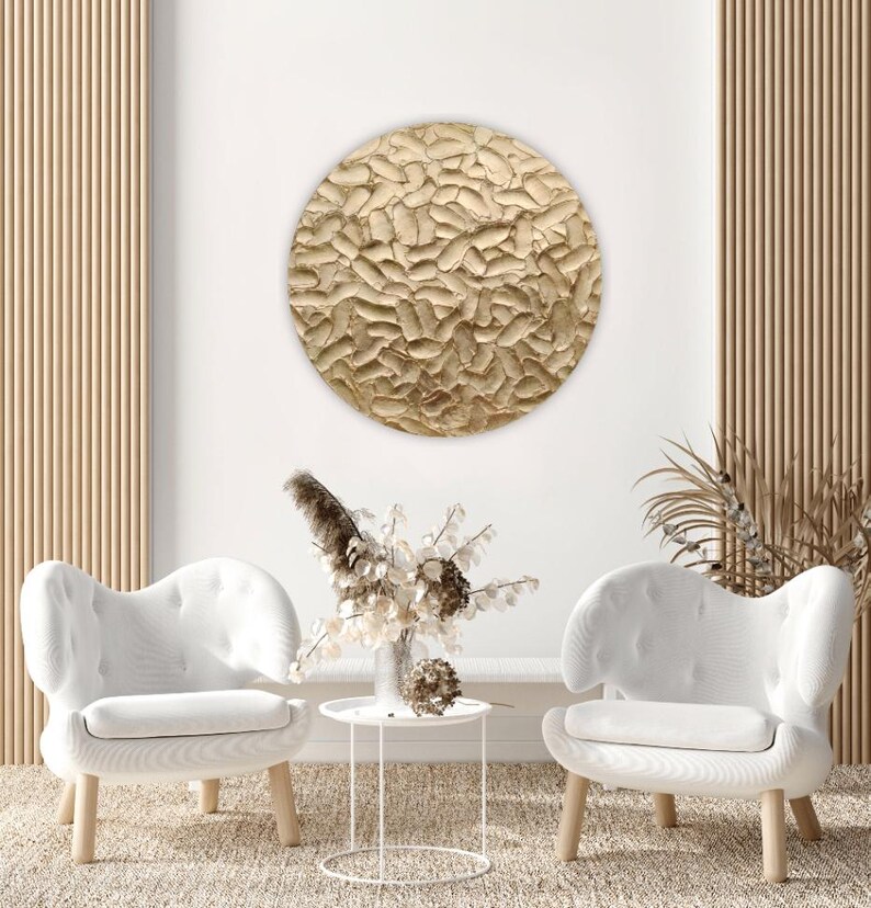 Circular gold painting with textured and sculptural details, perfect for adding elegance to living room wall decor.