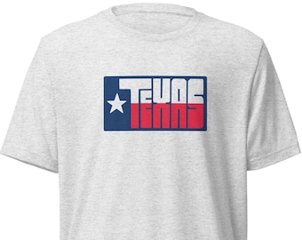 May include: A heather grey t-shirt with a blue and red graphic of the Texas flag with the word "Texas" written in white letters.