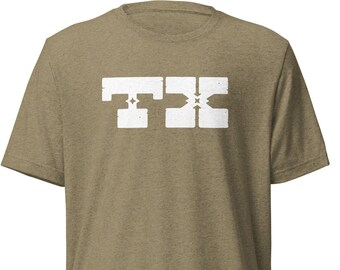 May include: A short-sleeved, olive green t-shirt with a white graphic. The graphic features the letters "TXC" in a bold, blocky font. The shirt is made of a soft, textured material.