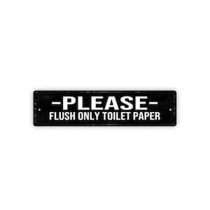 May include: A rectangular black sign with white text that reads "-PLEASE- FLUSH ONLY TOILET PAPER". The sign has a distressed, vintage appearance, with a white background.