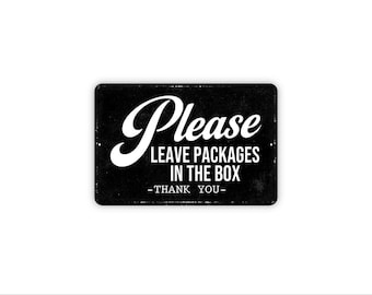 May include: A rectangular black metal sign with white text that reads Please LEAVE PACKAGES IN THE BOX -THANK YOU-. The sign features a distressed texture and a bold, high-contrast design with a script font for the word Please.