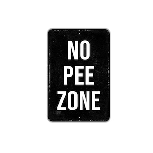 May include: A rectangular black metal sign with rounded corners featuring the white text NO PEE ZONE in a bold sans-serif font. The sign has a slightly distressed, textured appearance with small mounting holes at the top and bottom center.