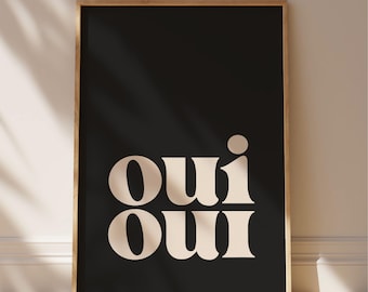 May include: A rectangular wall art print in a light wood frame featuring a solid black background with the word "oui" printed twice in a stacked format using a large, bold, cream-colored serif typeface with rounded edges and a dot above the i.