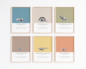 May include: Six framed wall art prints featuring black and white dinosaur skeleton illustrations on solid colored backgrounds. Each print displays the dinosaur name, phonetic pronunciation, and historical facts in black text on a white base.