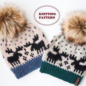 May include: Two knitted hats with faux fur pom poms. The hats feature a fair isle pattern with moose and hearts. One hat has a blue brim and the other has a green brim.  "Knitting Pattern" is written in red on a white oval.
