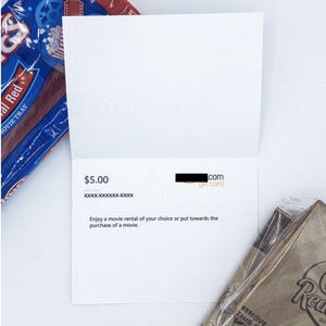 May include: A white gift card with a $5.00 value. The card is from [redacted] and can be used for a movie rental or purchase.