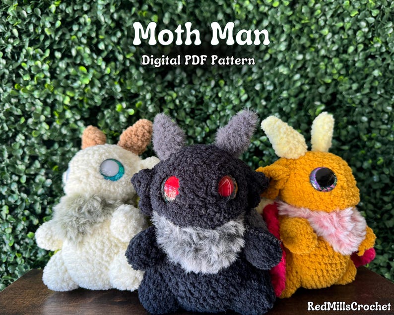 May include: Three crocheted plush toys in the shape of moths. The moths are in different colors: white, black, and orange. The white moth has a light blue eye, the black moth has a red eye, and the orange moth has an orange eye. The text "Moth Man Digital PDF Pattern" is at the top of the image.