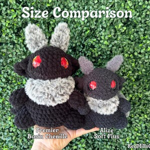 May include: Size comparison of two crocheted plush toys. The larger toy is black with gray fur and red eyes, labeled "Premier Basic Chenille". The smaller toy is black with gray fur and red eyes, labeled "Alize Soft Plus".