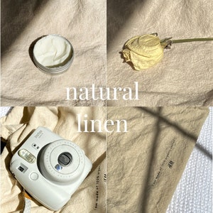 May include: A white instant camera with a brown leather strap, a jar of white cream, a dried flower, and a piece of beige linen fabric with the text "I am made of 100% organic linen" and the logo "H&M" printed on it.