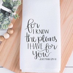 May include: White kitchen towel with black text that reads "For I know the plans I have for you - Jeremiah 29:11"