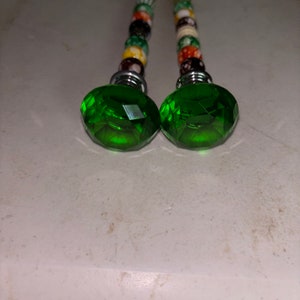 May include: Two green crystal door knobs with silver metal bases and colorful beaded stems.