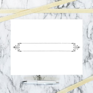 May include: A white card with a black decorative border. The card is on a marble surface with two gold ribbons.