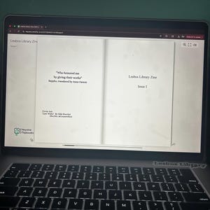 May include: A laptop displaying the open pages of a digital zine titled "Lesbos Library Zine, Issue 1." The left page features a quote by Sappho, translated by Anne Carson. The cover art is by Kiki Buccini. The laptop keyboard is visible.