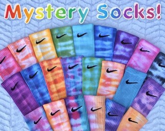 May include: A collection of tie-dye socks with a black Nike swoosh logo. The socks are in various colors, including blue, green, orange, pink, purple, and yellow.