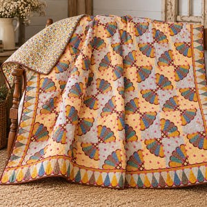 May include: A quilted bedspread featuring a repeating fan pattern in shades of yellow, blue, and red on a light background. The quilt has a decorative border with triangular shapes and a reverse side with a small floral print pattern.