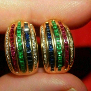 Peut inclure: Une paire de boucles d'oreilles créoles en or avec un design de pierres précieuses multicolores. Les boucles d'oreilles sont serties de rangées de pierres précieuses rouges, vertes et bleues, et sont rehaussées de petits diamants.