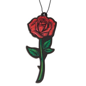May include: A red rose with green leaves and a black stem on a black background. The rose is hanging from a black string.