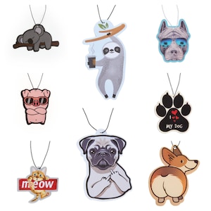 May include: Set of nine car air fresheners with various animal designs. The designs include a koala, sloth, pig, dog paw print, pug, and corgi. The air fresheners are printed on white cardstock and have black string hangers.