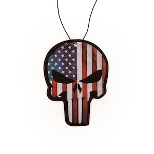 May include: A car air freshener shaped like a skull with the American flag design. The skull is black and the flag is red, white, and blue.