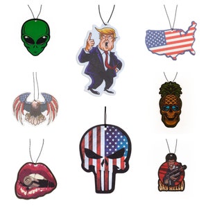 May include: Set of nine car air fresheners with various designs.  The designs include a green alien, a man in a suit, a pineapple skull, a skull with an American flag, a red mouth with a bullet, an American flag, a bald eagle, and a man with a gun.  The text on the air freshener says "Say Hello".