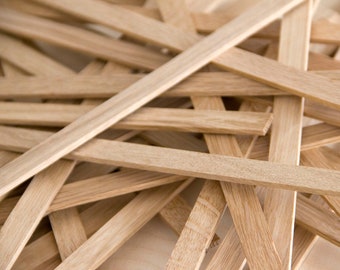 May include: A pile of natural wood strips, likely for crafting or woodworking projects. The strips are light brown and have a smooth, unfinished surface.