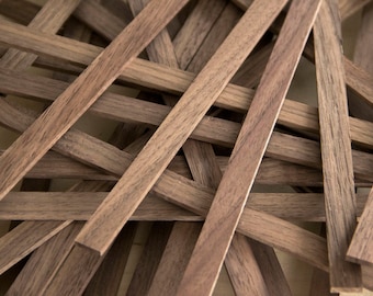 May include: A pile of dark brown wooden strips, likely for crafting or woodworking projects.