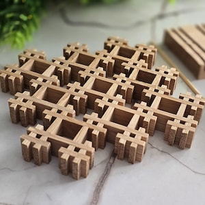 Könnte beinhalten: Ein Untersetzer aus Holz mit geometrischem Design. Der Untersetzer ist aus hellbraunem Holz gefertigt und hat ein Gittermuster.