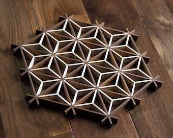 May include: A geometric wooden wall art piece with a white inlay design. The piece is made of dark wood and has a hexagonal shape.