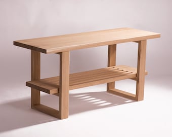 May include: A light wood bench with a shelf and slatted bottom. The bench is made of solid wood and has a natural finish.