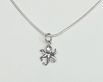 Puede incluir: Un collar de cadena de plata con un pequeño colgante de pulpo de plata.