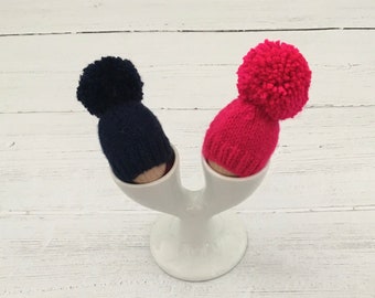 Set of two knitted egg cozies, navy and hot pink