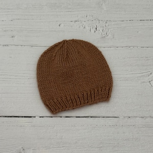 Peut inclure: Un bonnet en tricot marron. Le bonnet est fait d'un fil doux et texturé.