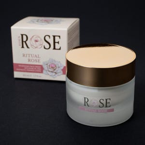 May include: A frosted glass jar of Eden Rose Ritual Rose nourishing face cream with a metallic gold lid, accompanied by its matching white cardboard box featuring rose illustrations and the text Eden Rose Ritual Rose 50 ml 1.7 fl oz.