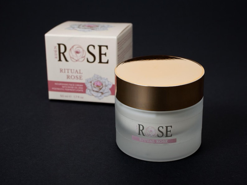 May include: A frosted glass jar of Eden Rose Ritual Rose nourishing face cream with a metallic gold lid, accompanied by its matching white cardboard box featuring rose illustrations and the text Eden Rose Ritual Rose 50 ml 1.7 fl oz.