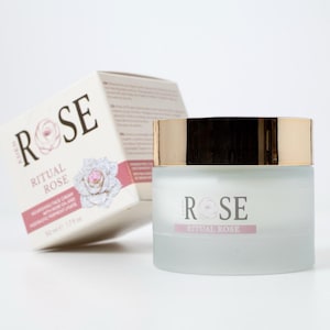 May include: A frosted glass jar of Ritual Rose nourishing face cream with a metallic gold lid, accompanied by its matching white cardboard box. The packaging features the text Ritual Rose, a rose illustration, and the volume 50 ml 1.7 fl oz.