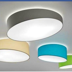 May include: Four round ceiling light fixtures with fabric shades. The shades are in grey, beige, blue, and green.