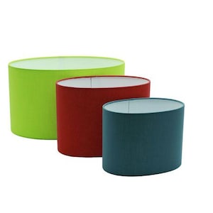 Peut inclure: Trois abat-jours cylindriques de différentes tailles et couleurs. Le plus grand est vert citron, celui du milieu est rouge et le plus petit est bleu sarcelle. Tous ont des intérieurs blancs et une texture lisse semblable à du tissu.
