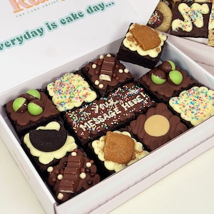 May include: A box of nine assorted brownie bites with various toppings, including sprinkles, chocolate, and sweets. The box is white with the text "everyday is cake day..." on the lid.